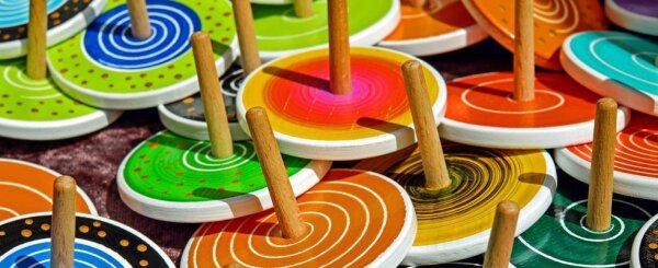 Bunte Holzkreisel mit Griffen, liegend auf einer Oberfläche