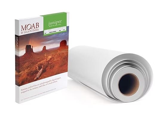 Eine Rolle Fotopapier und eine Schachtel MOAB Papier mit einer weiläufigen Landschaft auf dem Etikett